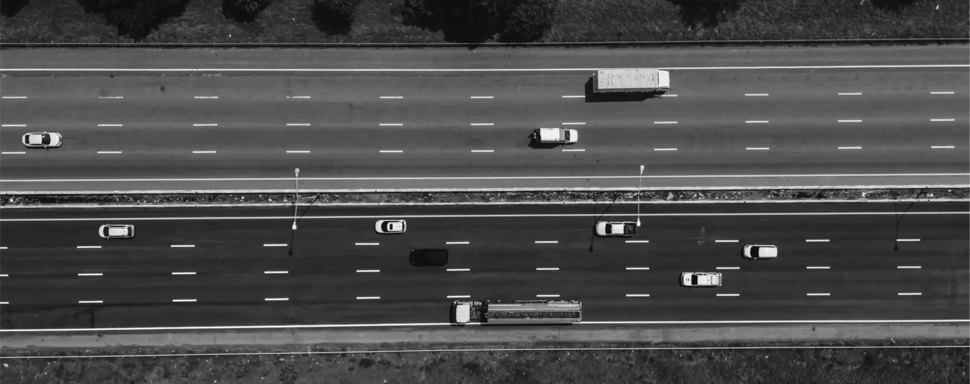 Aerial view of freight trucks and cars moving along a multi-lane highway