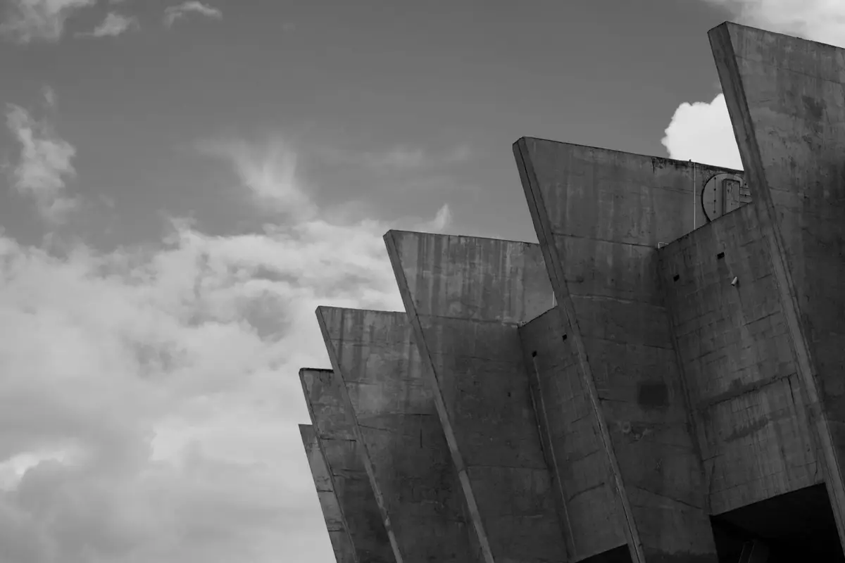 Concrete structural fins of a brutalist building rising against the sky