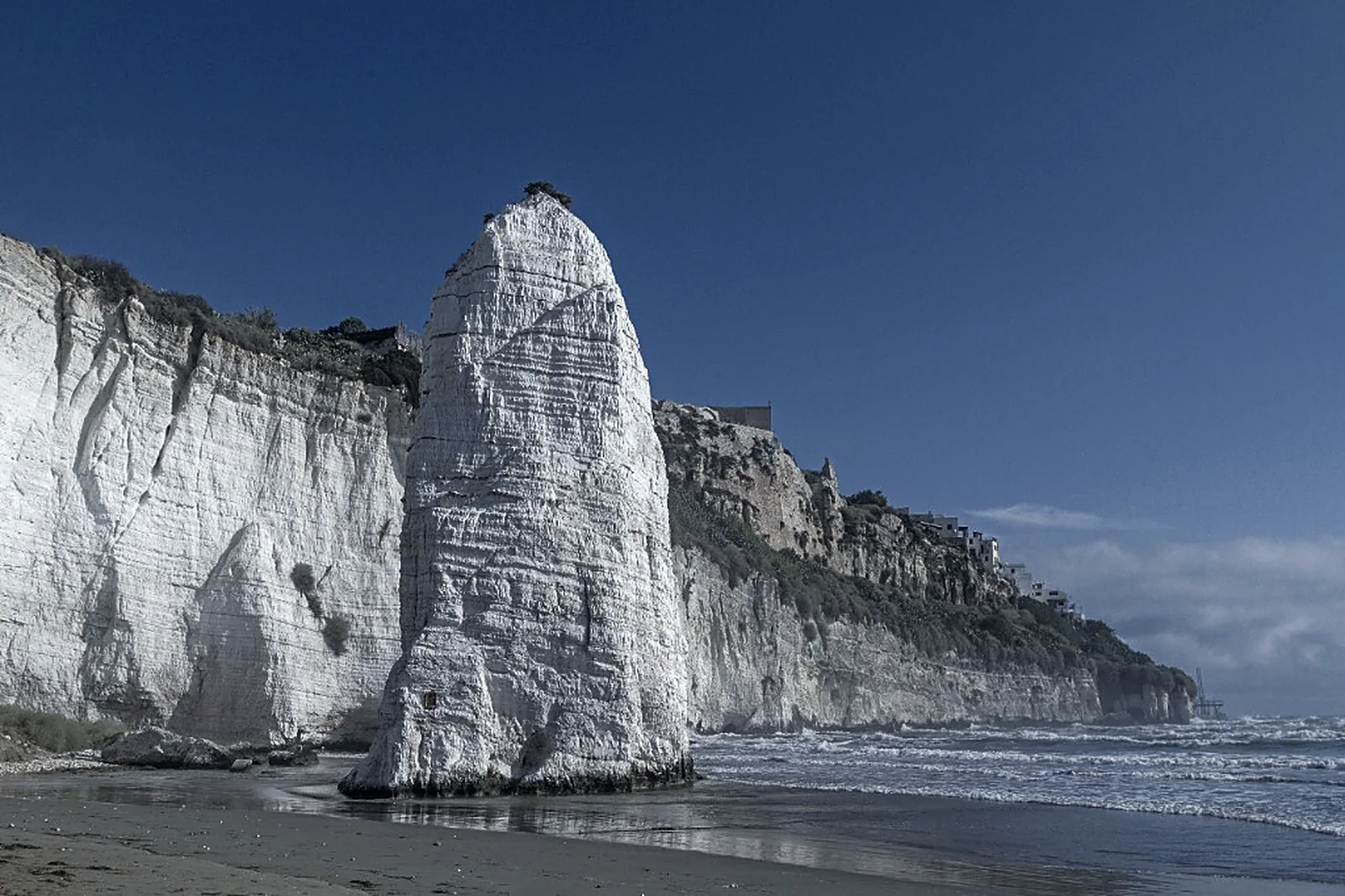 A limestone sea stack standing on its own foundation, apart from the cliff line it broke away from
